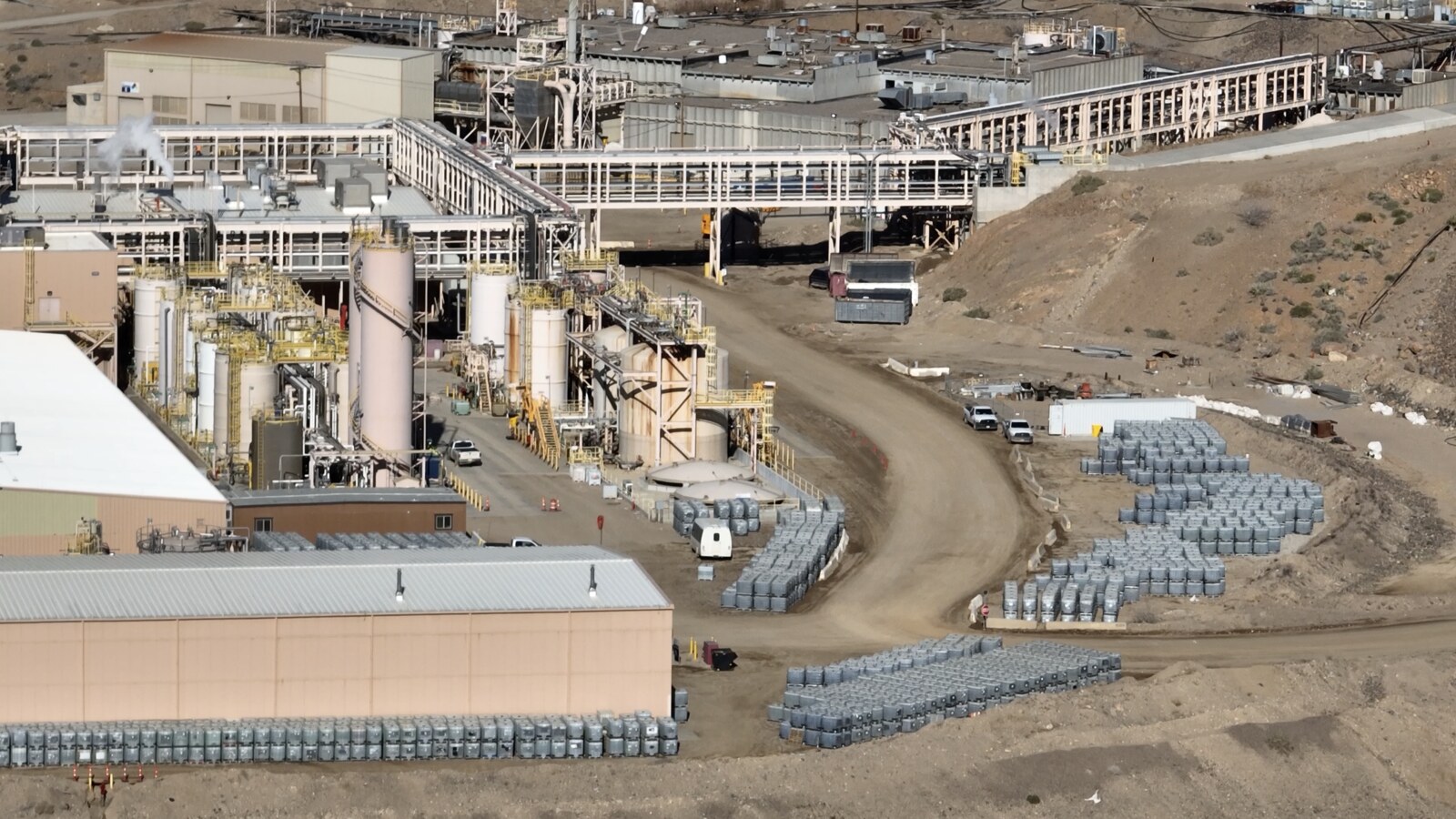 Close-up view of the MP Materials processing complex at Mountain Pass with storage drums staged near the refining facility