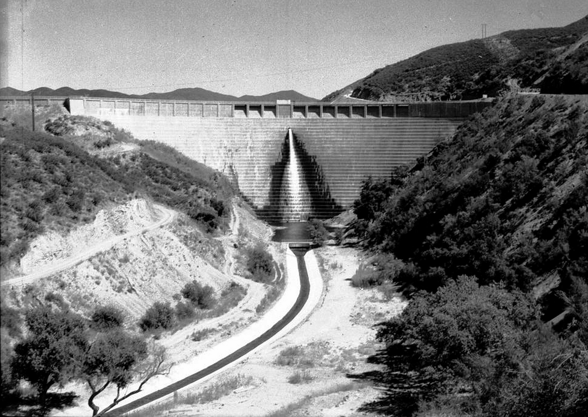 The St. Francis Dam spans San Francisquito Canyon in early 1928, shortly before its collapse sent a deadly flood between the canyon walls.